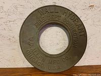 Front side of bronze fire hydrant collar showing embossed text: WALL HYDRANT FIRE DEPT CONNECTION W.D. ALLEN MFG. CO. CHICAGO, U.S.A.
