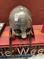 Front view of metal Viking style helmet with mask and leather liner visible