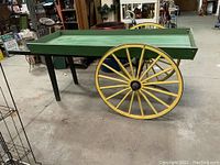 Side view showing green deck, yellow spoked wheel and black support leg