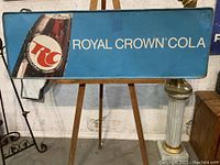 Full front view of the large vintage metal marquee sign with Royal Crown Cola branding on blue background, showing the bottle image and RC logo with text.