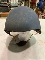 Front view of WWII MK 2 USN Talker Flak Helmet showing blue textured finish and brown chin strap.