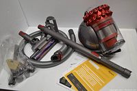 Vacuum body and attachments laid out on white surface