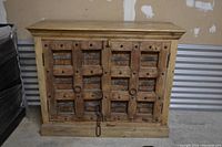 Front view of wooden vintage cabinet showing detailed wood and iron hardware on doors.