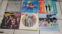 Photo showing 7 vintage Monkees vinyl album covers including titles like 'Changes,' 'The Monkees 1967,' and picture discs with band images.