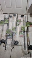 Full view of seven sealed fishing combos each with rod, reel, and kit