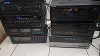 Overall view of seven audio components stacked on floor