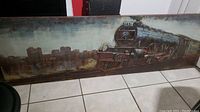 Front view of the large rectangular metal wall art showing the steam locomotive train and city skyline painted background.