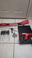 Full view of Snap-on tools including ratchet, screwdrivers, sockets, power tool, and extensions laid on floor.