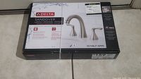 Box of Delta Sandover faucet model 35748LF-SPPD with packaging label showing product image and price tag.