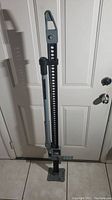 Full view of the Smittybilt 54-inch Trail Jack showing the handle, bar with holes, and foot plate.