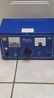 Full front view of the Swest Electroplater showing meters, control knobs, output terminals and blue casing.