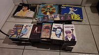 Photo of multiple Elvis Presley vinyl albums and audio cassettes stacked, showing album cover portraits and cassette cases.
