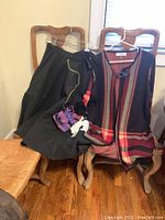 Photo of black felt poodle skirt and plaid Jones Studio jacket with top clasp hanging on chairs