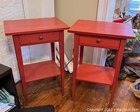 Two red IKEA Hemnes nightstands placed side by side showing overall shape, color, and condition.