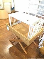 Full view of white wicker rattan bed tray on foldable wooden stand showing tray and stand assembly.