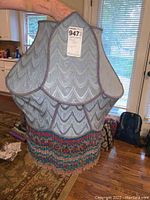 Front and side view of large blue Victorian-style lamp shade with scalloped fabric panels and beaded fringe.
