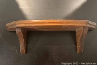 Top view of the wooden wall shelf showing the beveled edge and side supports