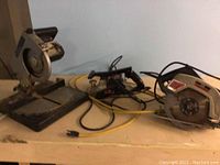 Photo showing side view of the mitre saw, circular saw, and belt sander on a wooden surface.