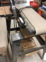 Side view of Craftsman belt sander showing sanding belt and metal stand frame.