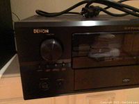 Front panel of Denon audio-video receiver showing volume knob, input selector and display