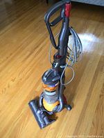Front view of Dyson DC25 upright vacuum on hardwood floor