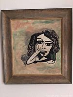 Framed abstract portrait art of a stylized face with curly hair, hand near face, in a bronze-toned frame, measuring 21x22 inches.