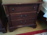 Close-up front view of one night table showing drawer configuration and finish.