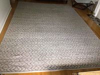 Full view of rectangular 9x13 ft rug laid on hardwood floor