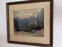 Framed watercolour landscape painting hanging on wall, showing full frame and matting.