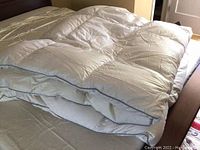 White queen size duvet laid out on a bed showing baffle box construction and edging detail