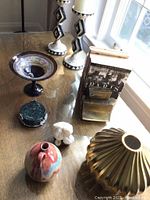 Wide top-down view of all miscellaneous decorative items showing placement on glass table and sunlight from window.