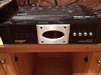 Frontal view showing the display, control buttons, and Monster Power logo on the left with a silver oval LED display in the center.