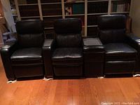 Front view of three black leather reclining seats