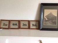 Five framed pieces include one vintage black and white railway photograph in black frame and four framed needlepoint train engine pictures in square wood frames.