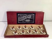 Red cardboard presentation box with lid removed showing ten mounted cavalry figurines inside.