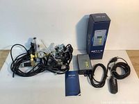 Overall lot arrangement on floor showing controller, two regulators, cables, instruction manual, and box.