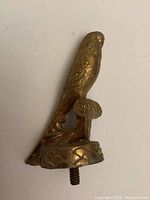 Side angle view of cast metal parrot finial with threaded stud