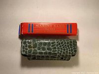 Marine Band No. 365 red box with green faux alligator case on top.