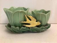 Close front view of McCoy double flower planter with two connected green flower pots and yellow bird on leaf-shaped base