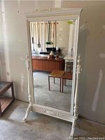 Front view of full mirror showing painted carved frame and swivel base