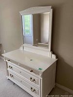 Full view of painted white dresser with attached mirror against wall
