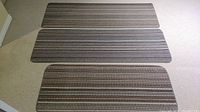 Three carpet runners arranged side by side on light carpeted floor, showing the size and pattern of each runner.