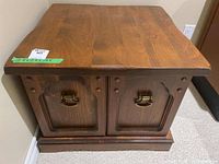 Front view of square wooden end table with cabinet doors and ring pull handles