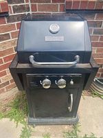 Front view of black Master Forge BBQ with lid closed, showing control knobs and door handle.