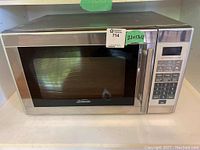 Front view of Sunbeam stainless steel microwave showing door, handle, and digital keypad.