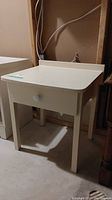 Photo of the white small table with single drawer and round knob