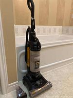 Full view of the Eureka upright vacuum cleaner showing the unit, handle, hose, and rotatable brush base.
