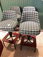 Four plaid swivel bar stools grouped in front of beadboard wall