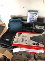 Camping equipment displayed on floor including boxed Outbound double air bed, Certified air compressor box, backpacks, and other gear.