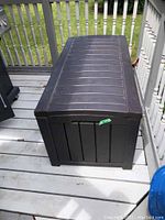 Closed deck box on wooden deck, showing overall appearance and condition